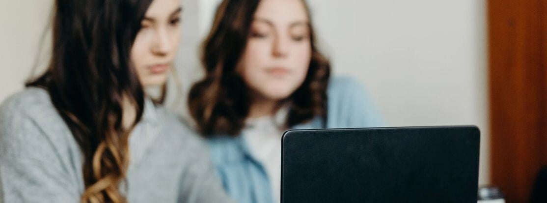 Mujeres revisando su identidad profesional en una laptop